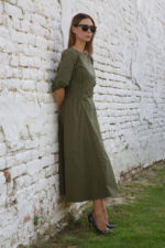 ZUMO FASHION maslinasta midi haljina od trenča rađena po meri. Elegantan A kroj i puf rukavi savršeni su za poslovne prilike.